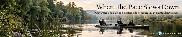 Where the pace slows down, people in a kayak in the river next to a hiking mountain